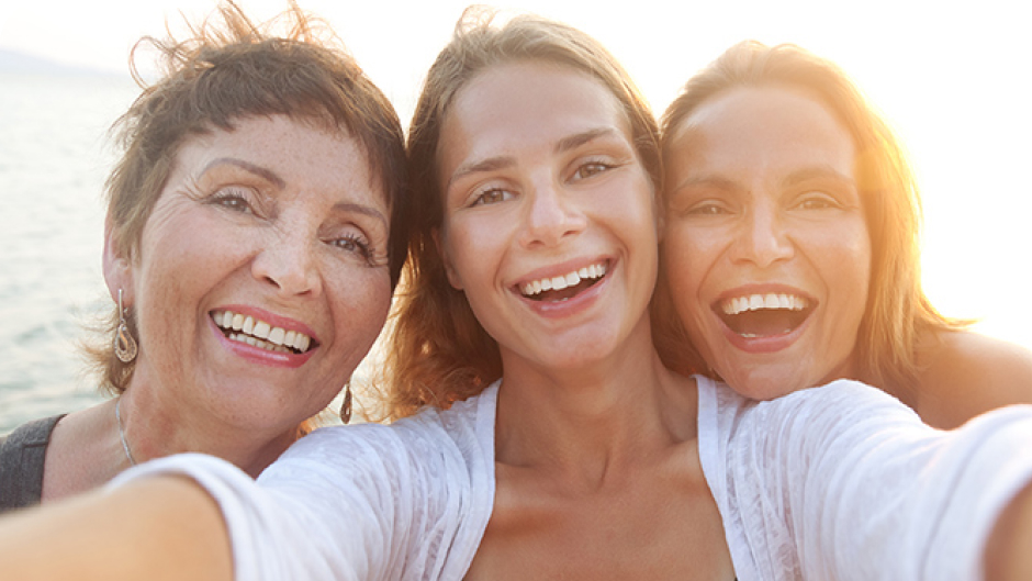 Three women outside taking photo together